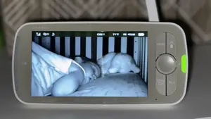 Black and white video footage of sleeping child on the screen of the Infant Optics DXR-8 Pro baby monitor.