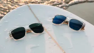 2 pairs of O'Neill x GlassesUSA.com Harwood 2.0 glasses sit on a surfboard in the sand