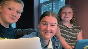author seated at computer with kids