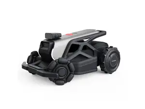 Grey and black AirSeekers Tron Robot Lawn Mower sitting on grass, in front of a wooden fence and bush.