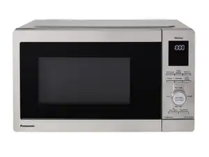 A pair of stainless-steel microwaves sit side by side on a wood-grain countertop.
