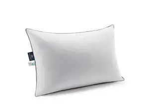 Two white Pacific Coast Feather & Down Pillows on a bed with floral sheets and a wooden barred headboard.