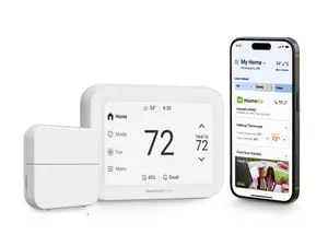 Three black and two white smart thermostats sit on an orange background