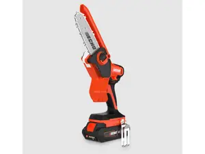 Six chainsaws sitting on the ground outside near a tree stump
