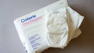 White Coterie The Diaper package with two diapers laying on top of it.