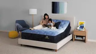 A mother and child reading on a Serta mattress set on an adjustable base in a cozy bedroom.