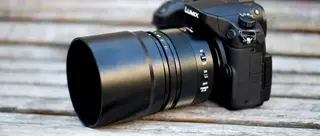 Angle on a black Lumix camera with a large zoom lens attachment on it.