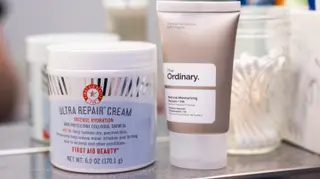 A jar and tube of moisturizer next to each other on a shelf.