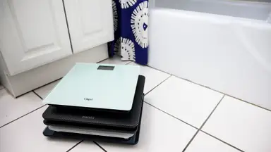A stack of scales on a bathroom floor