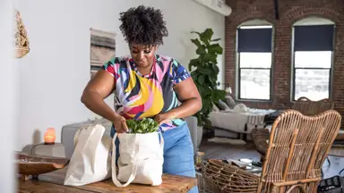 A woman storing groceries she paid for with a credit card