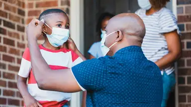 Father adjusting his son's face mask