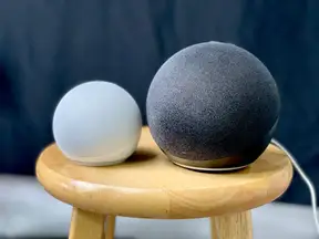 Two Echo Dot speakers on a side table.