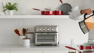 The Cuisinart TOA-60 air fryer toaster oven sitting on a kitchen counter.