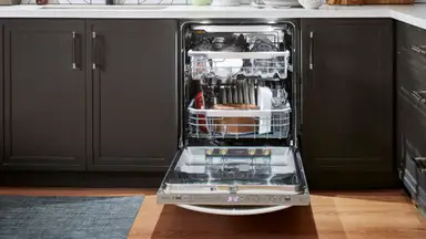 The LG dishwasher, installed in a modern kitchen setting, completely loaded up with dishes.