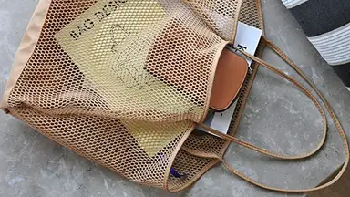 A beach bag being used to store items for a beach trip.