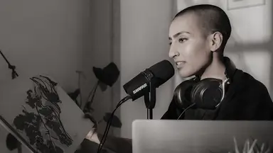 A model demonstrates the use of the Shure MV7 podcasting microphone.