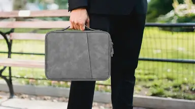 A man carrying his tablet in his tablet case to work.