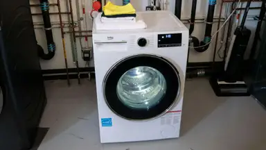The white washing machine sits in the Reviewed Labs with its drum light on.