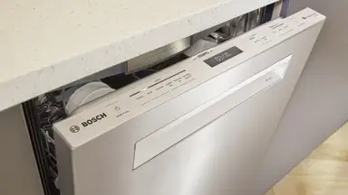 Slightly open Bosch dishwasher in a kitchen.