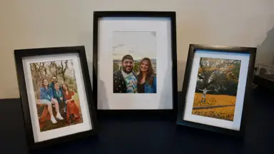 Three Frameology black photo frames are displayed on a blue hutch.