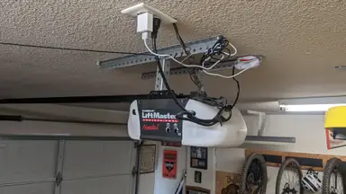 The Meross Garage Door Opener hanging in a residential garage.