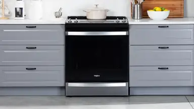 The Whirlpool WEE745H0LZ Electric Range in a modern kitchen between two sets of drawers.