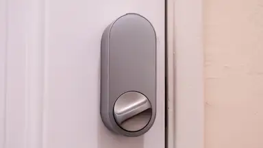 The Aqara U200 smart door lock shown in silver hanging on a white door.