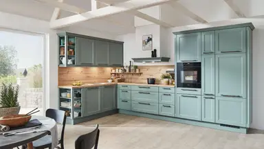A beautiful, sunny kitchen with two walls of cabinets painted green