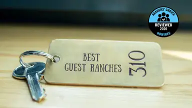 A brass hotel key with a room number on a table