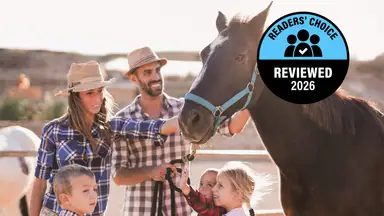 Family with young children petting a horse at a ranch, with a Reviewed Readers' Choice 2026 badge displayed.