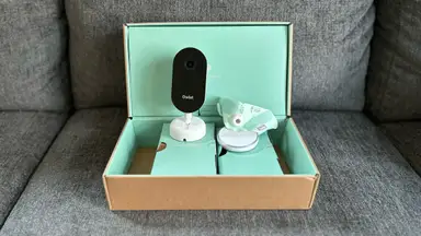 Owlet Dream Duo (Gen 3) components in mint green box sitting on a grey couch.