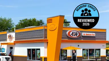 The exterior of an A&W Restaurants location with orange and brown branding and an "All American Food" sign, overlaid with a Readers' Choice Reviewed 2026 badge.