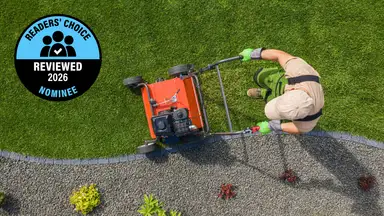 A service person mows a lawn