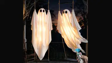 Two Dusfan swinging ghost decorations against a dark background.