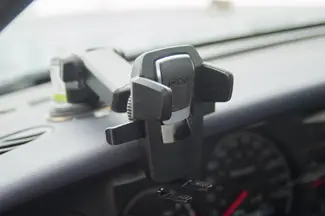 A phone holder mounted to the dashboard of a car