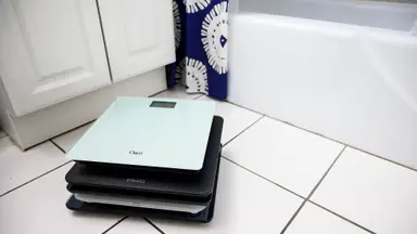A stack of scales on a bathroom floor