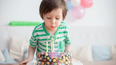 Boy blowing out birthday candles on cake