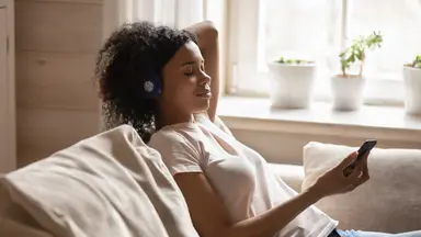 Woman sits on her couch meditating
