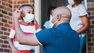 Father adjusting his son's face mask