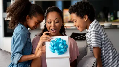 Two children give their mother a Mother's Day present.