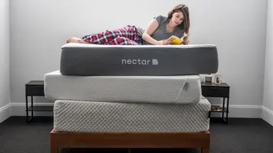 a woman lies down on a stack of mattresses reading