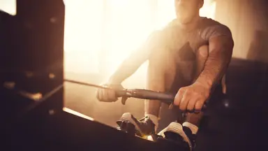 Man exercising on rowing machine.
