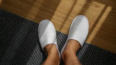Man wearing a pair of white slippers.