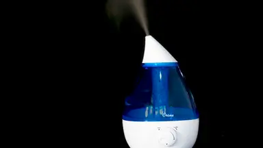 A white and blue humidifier on a black background