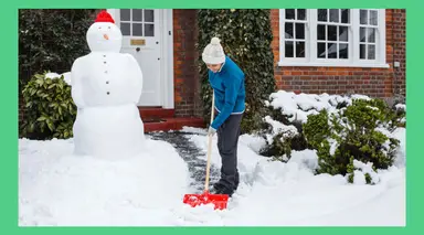A person shoveling snow in the front yard