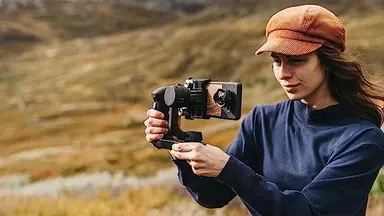 A woman using her iPhone lens to capture content.