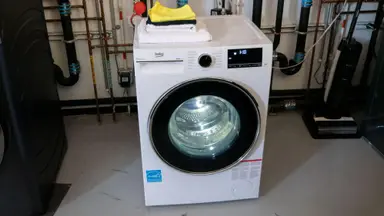 The white washing machine sits in the Reviewed Labs with its drum light on.
