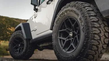 A set of black rims on a Jeep Wrangler.