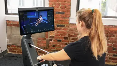 A woman taking a Peloton rowing class on the Row.