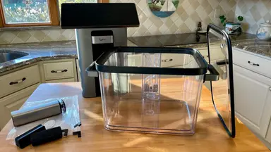The Typhur Sous Vide Station on wooden countertop inside of kitchen.